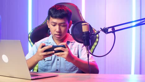 asian kid boy playing video game with mobile phone then lose the game while live stream