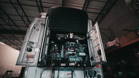 reefer trailer with front cover-doors opened in a mechanic shop waiting to get repaied by skilled mechanic