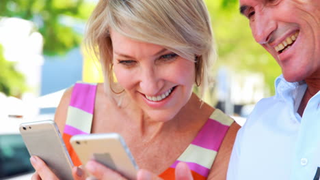 Smiling-couple-using-smartphones