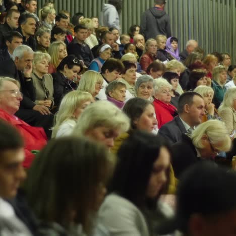 crowd of people to sitting and listening in a large hall