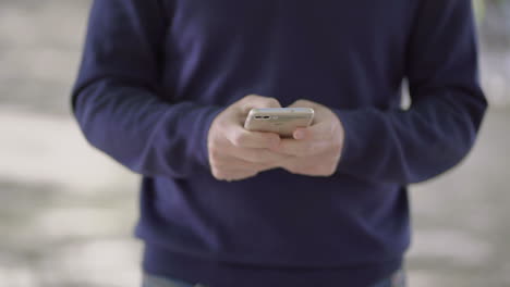 cropped shot of man using cell phone outdoor