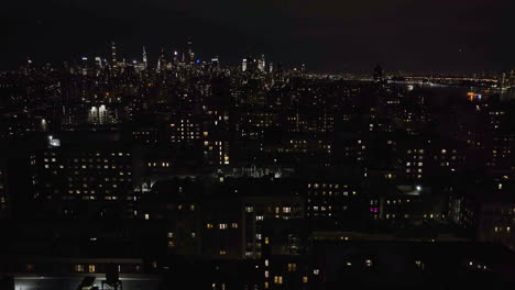 Aerial-view-low-over-illuminated-apartments-in-Morningside-heights,-night-in-NY,-USA