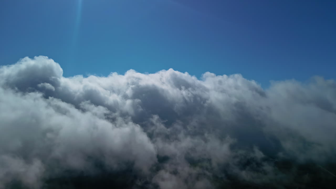 volando sobre un paisaje de nubes blancas y esponjosas, vista desde el interior del avión