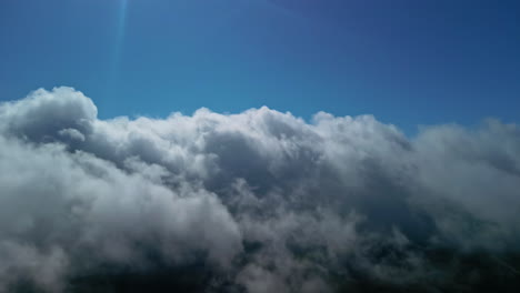 flying above white fluffy cloudscape, view from inside plane