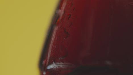 Close-Up-Of-Condensation-Droplets-Running-Down-Bottle-Of-Cold-Beer-Or-Soft-Drink-Against-Yellow-Background