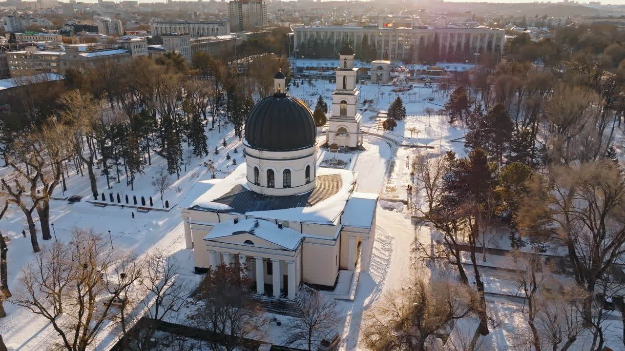 Aerial drone view of the Bell tower and the Metropolitan Cathedral of Christ's Nativity. City center covered in snow at sunset in Chisinau, Moldova