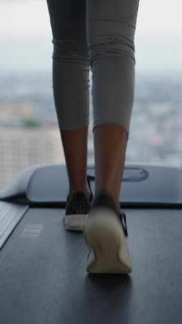 person exercising on a treadmill with a city view