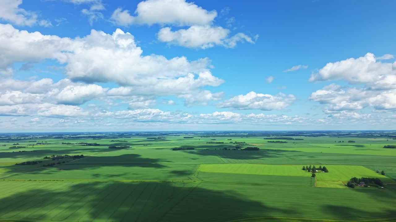 Drone overview of slowly shifting cloud shadows over symmetrical green crop field