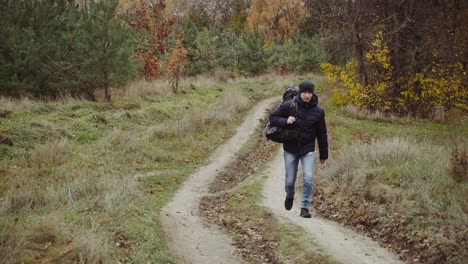 tourist with backpacks travel. tourist man with backpack on meadow in autumn forest