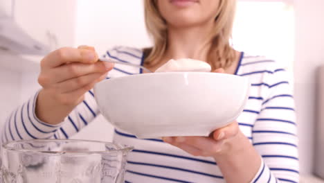 blonde woman preparing a smoothie