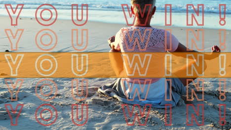 animation of you win text in repetition with orange stripe over woman practicing yoga by sea