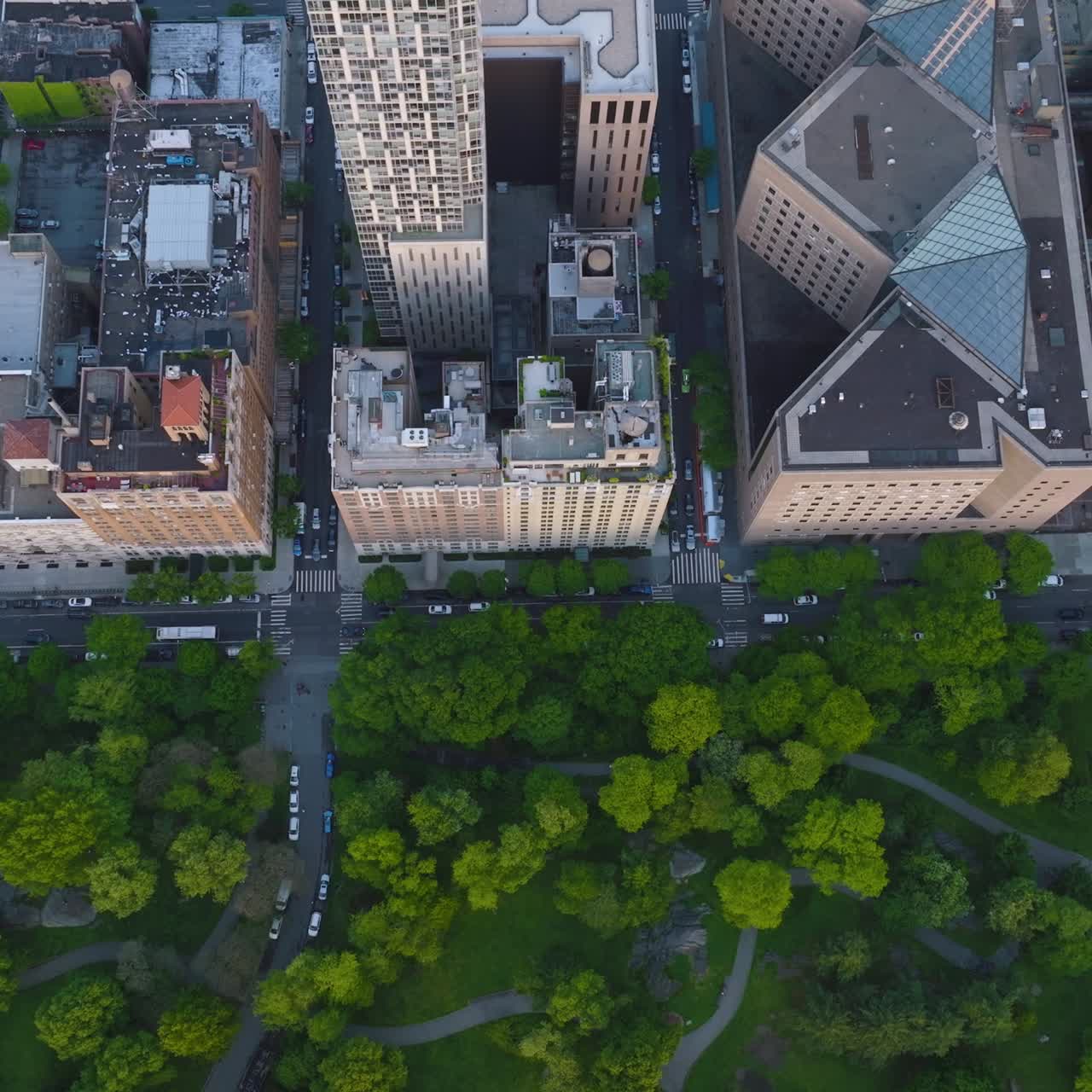 Large beautiful green park near the busy street. Drone footage over the great New York at daytime