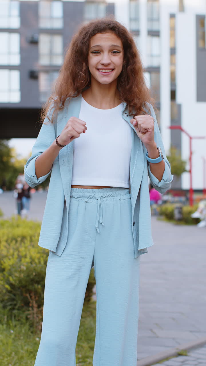 Preteen girl shouting celebrating success winning goal achievement good victory news in city street