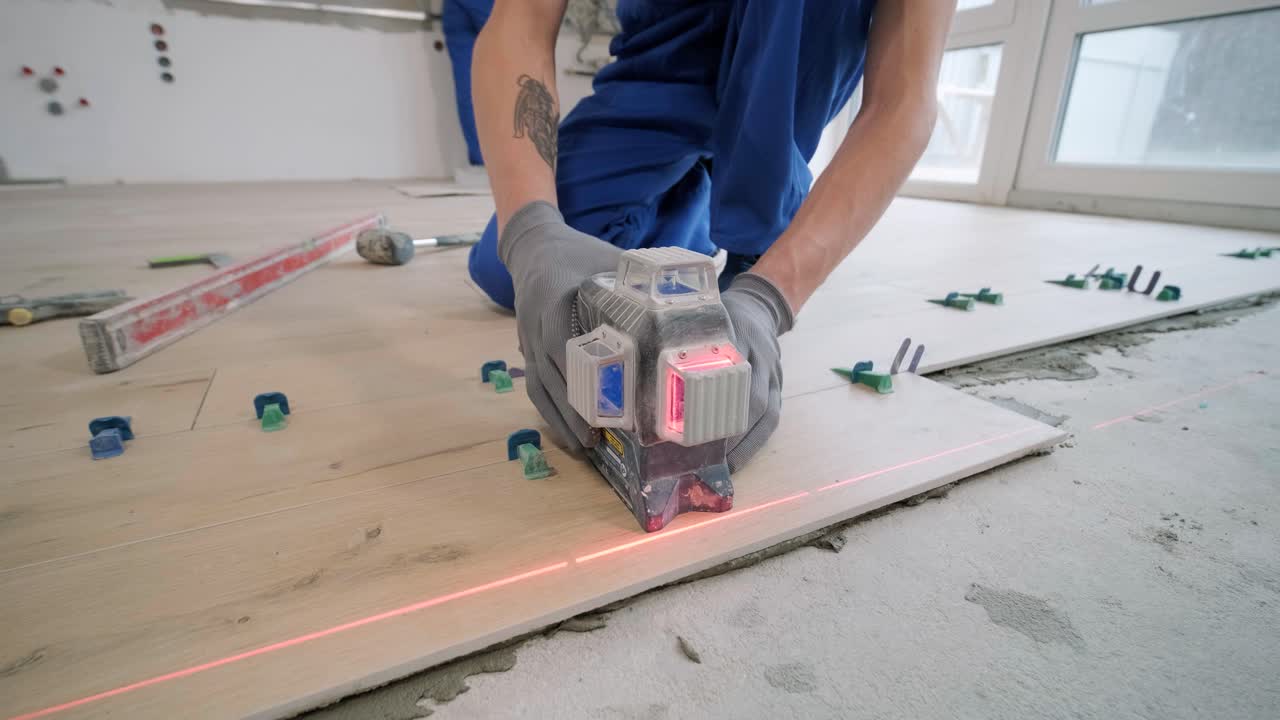 Installing ceramic floor tiles - measuring and cutting the pieces. Construction, renovation, repair apartment. Cuts tile. Tile cutting