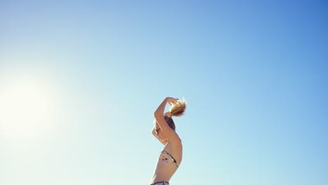 woman adjusting hair on a sunny beach day