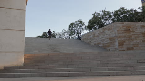 joven corredor negro bajando las escaleras y entrenando para maratón al aire libre