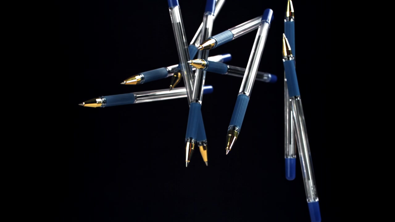 Blue and Gold Ballpoint Pens Floating and Rotating on Black Background