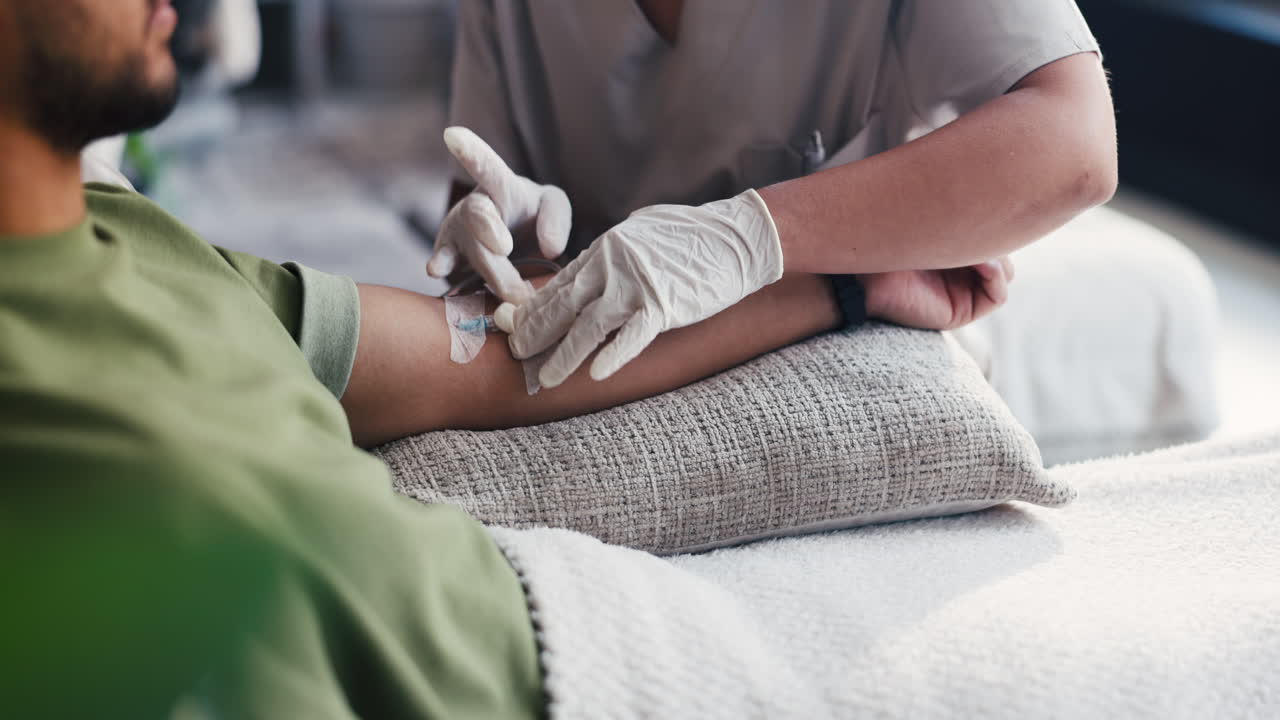 Medical Professional Administering IV Drip to Patient's Arm