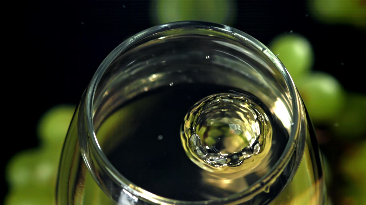 Slow Motion Drop of White Wine Splashing in Glass