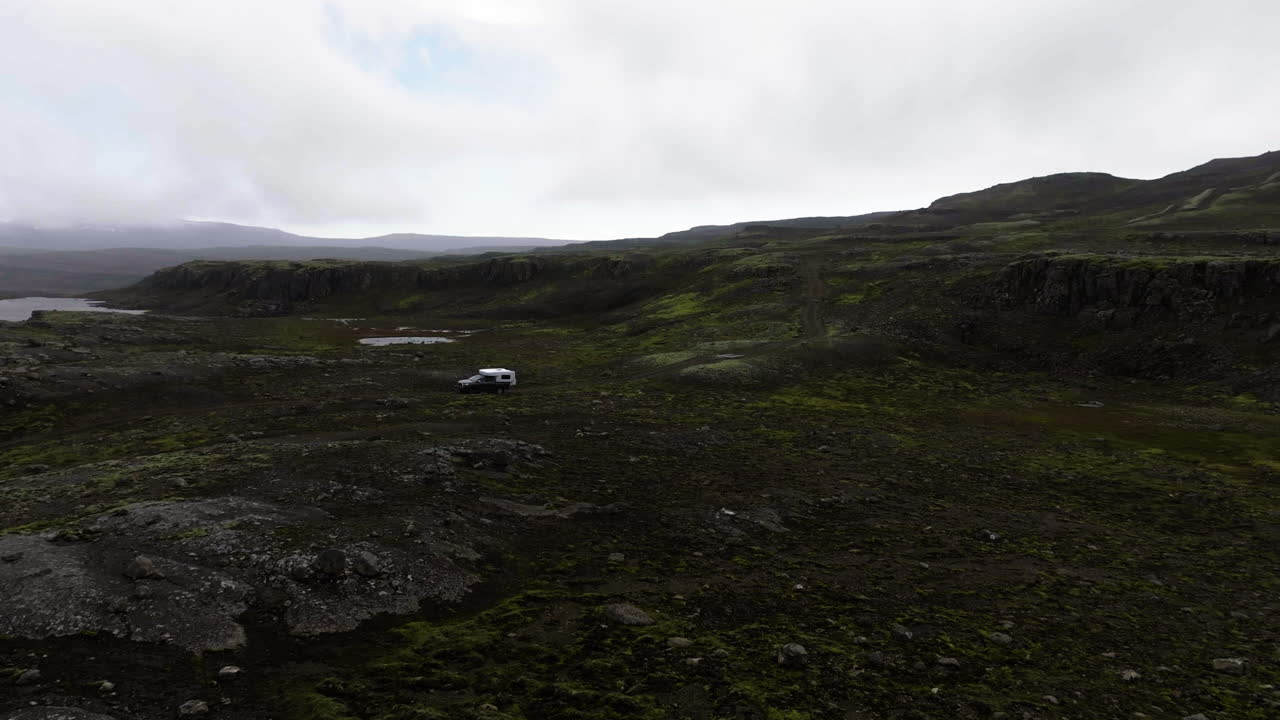 AERIAL: Overlanding truck, driving in rough nature in the wilderness of Iceland