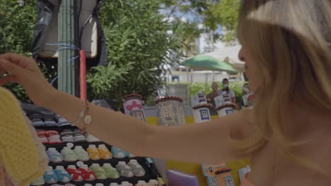 young pregnant lady shopping for cute baby clothes at an outdoor market