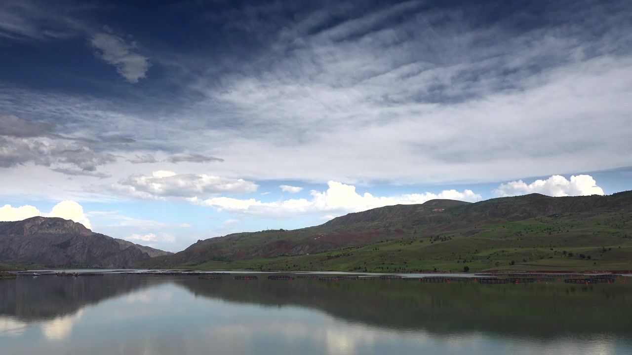Paesaggio lacustre sereno con dolci colline verdi e cielo nuvoloso