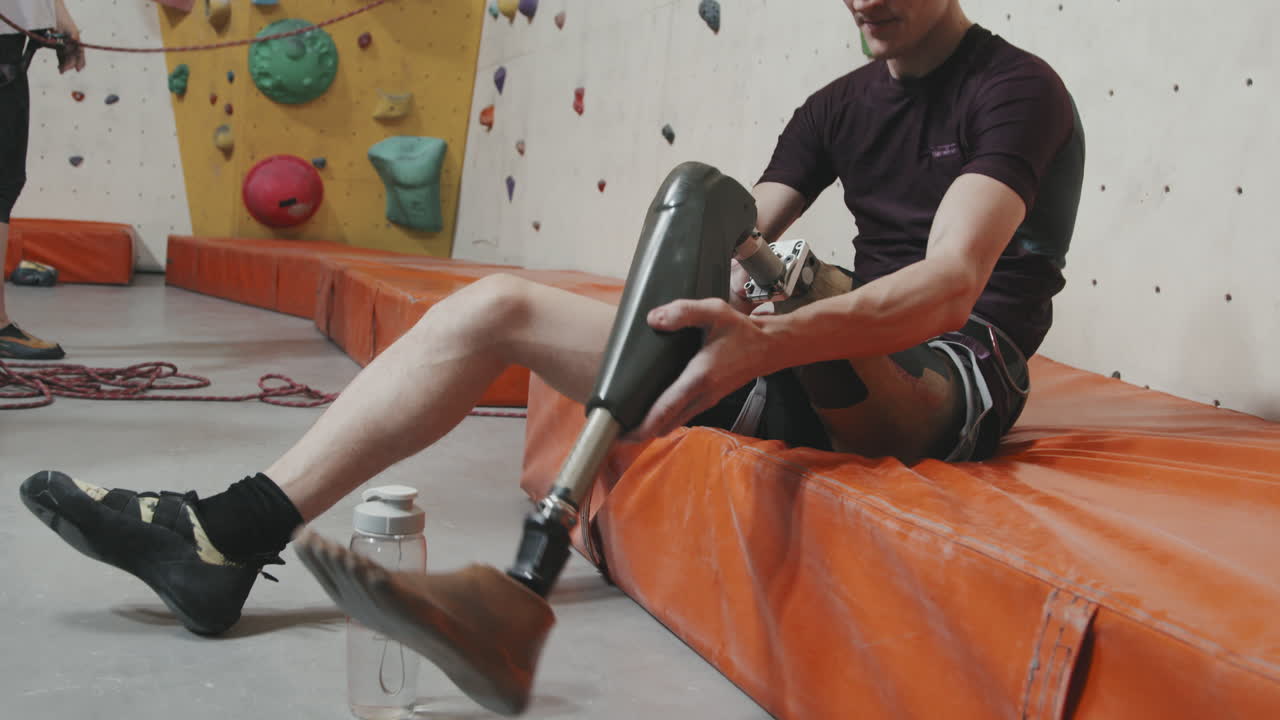 Male Athlete Wearing Leg Prosthesis Before Indoor Wall Climbing