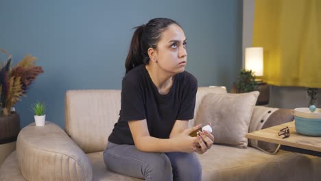 The-young-woman-who-looks-at-the-pills-in-her-hand-and-is-going-to-commit-suicide.