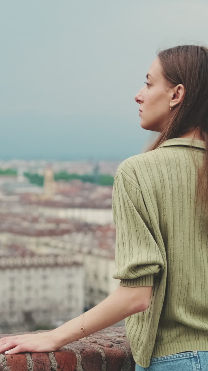 Giovane donna che osserva un panorama cittadino