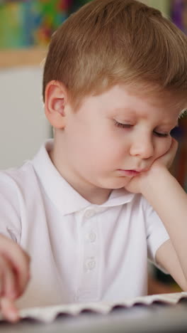schoolgirl comforts upset little brother during piano lesson at home closeup. toddler boy disinterested in music and careful elder sister in children room
