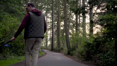 man together with dog walking in the path at washington park in anacortes, fidalgo island, usa