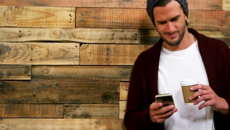 Man-using-mobile-phone-while-having-cup-of-coffee