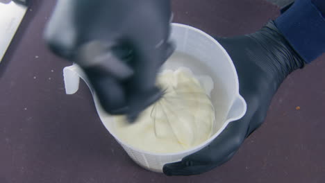 male cook stirs eggs and milk in bowl using whisk