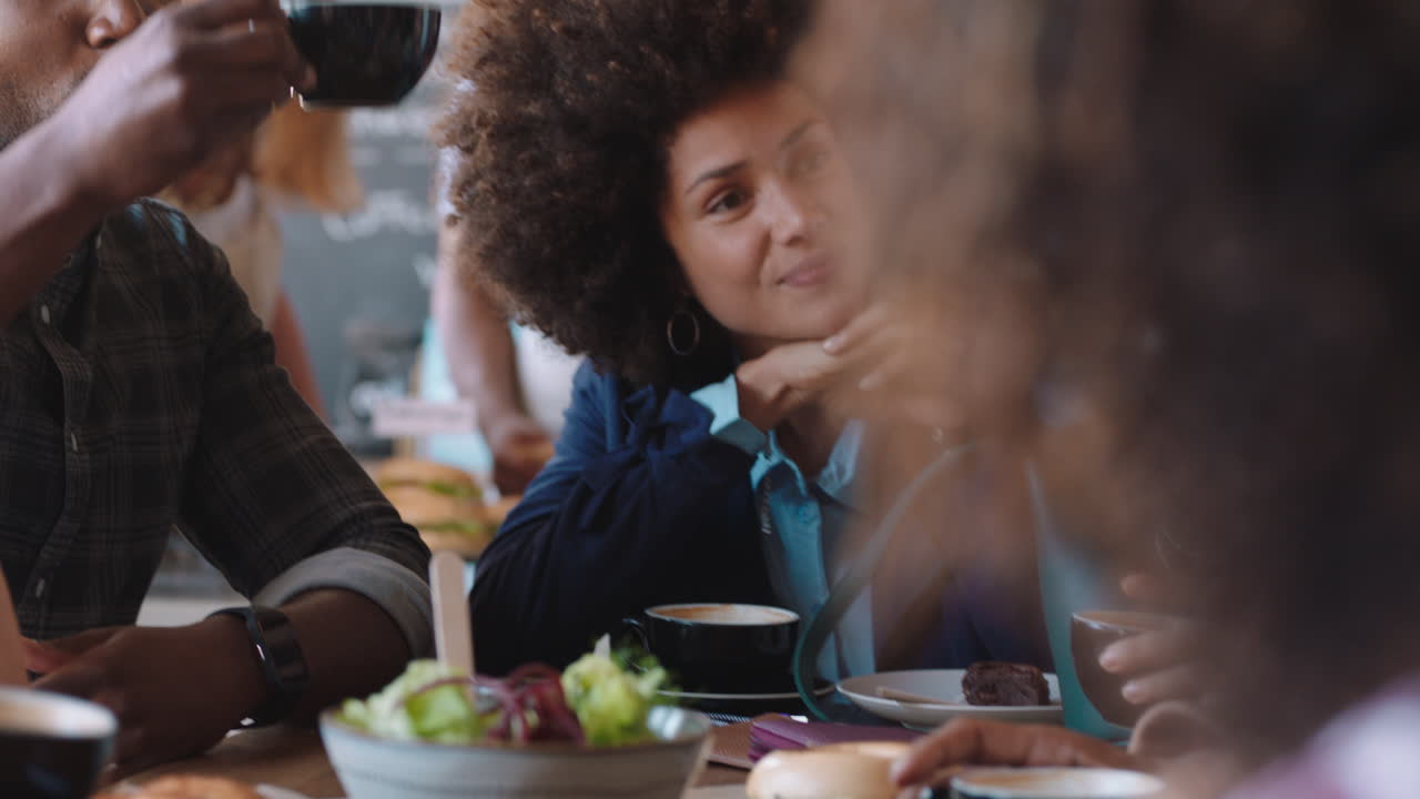 diverse group of friends hanging out in cafe chatting sharing conversation drinking coffee enjoying socializing having fun meet up in restaurant