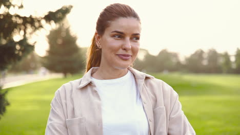 portrait of a beautiful woman smiling and looking at camera in the park 1