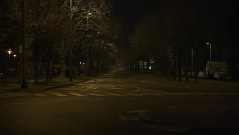 Deserted road with bare trees and warm lamps at night in Zagreb Croatia
