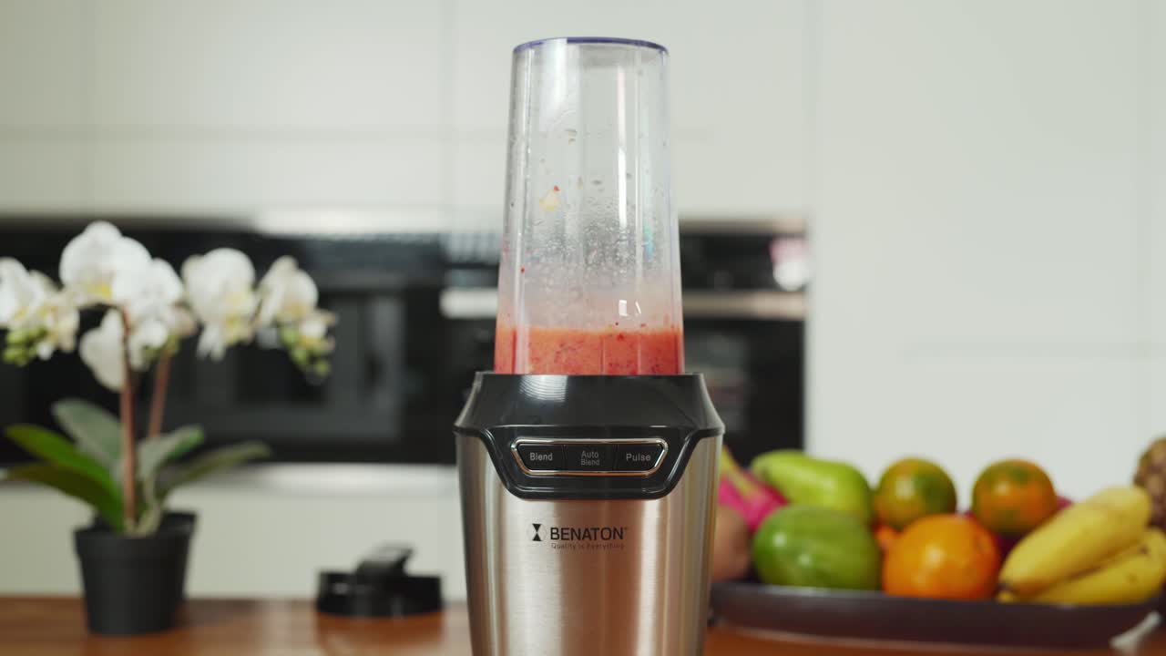 mano demostrando la facilidad de uso con un mezclador de jugo, progresando a través de las configuraciones