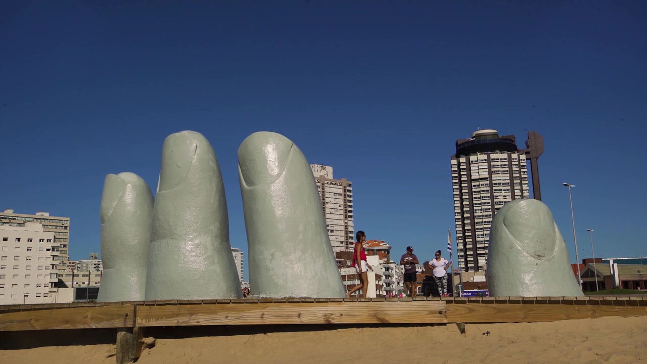 Turisti presso la statua della mano a Punta del Este, Uruguay