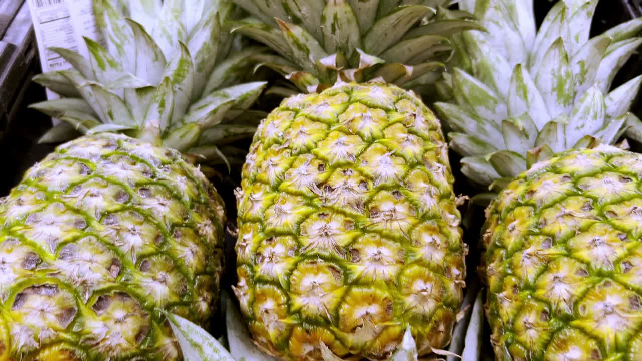 판매 구역에 배열된 여러 개의 파인애플을 확대합니다.