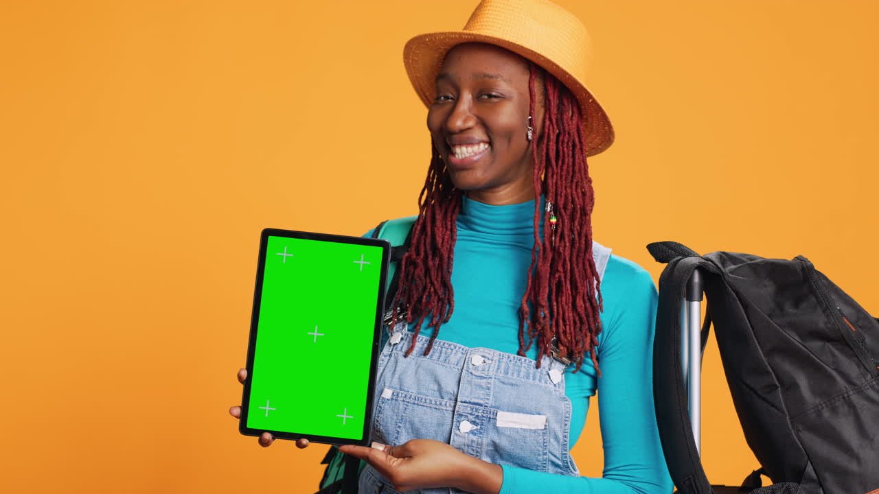 Cheerful woman holding tablet in studio