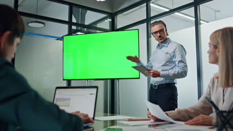 Geschäftsmann-Macht-Chromakey-Präsentation-Im-Büro.-Trainer-Zeigt-Auf-Grünen-Bildschirm