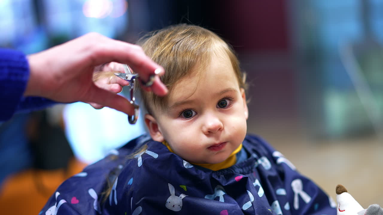 Bambino che si fa tagliare i capelli in un salone