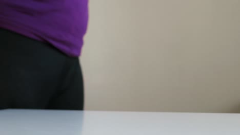 woman picking up pink hand weight, starting workout