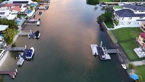 drone footage captures serene canals and waterfront homes in gold coast, australia, with soft evening light reflecting on the water