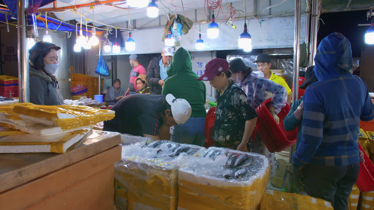 comerciantes clasificando pescado para su entrega en el mercado del puerto pesquero de tho quang, vietnam