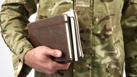 mid section of soldier holding dairy on white background