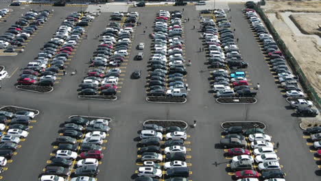 timelapse drone footage of parking lot, with people and cars moving around, static aerial