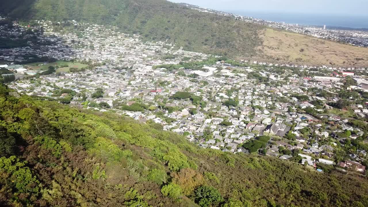 Manao suburb district with minder houses and homes surrounded by green mountains. Aerial top down shot. Honolulu city on Hawaii, USA. Sunny summer day. Peaceful cityscape neighborhood