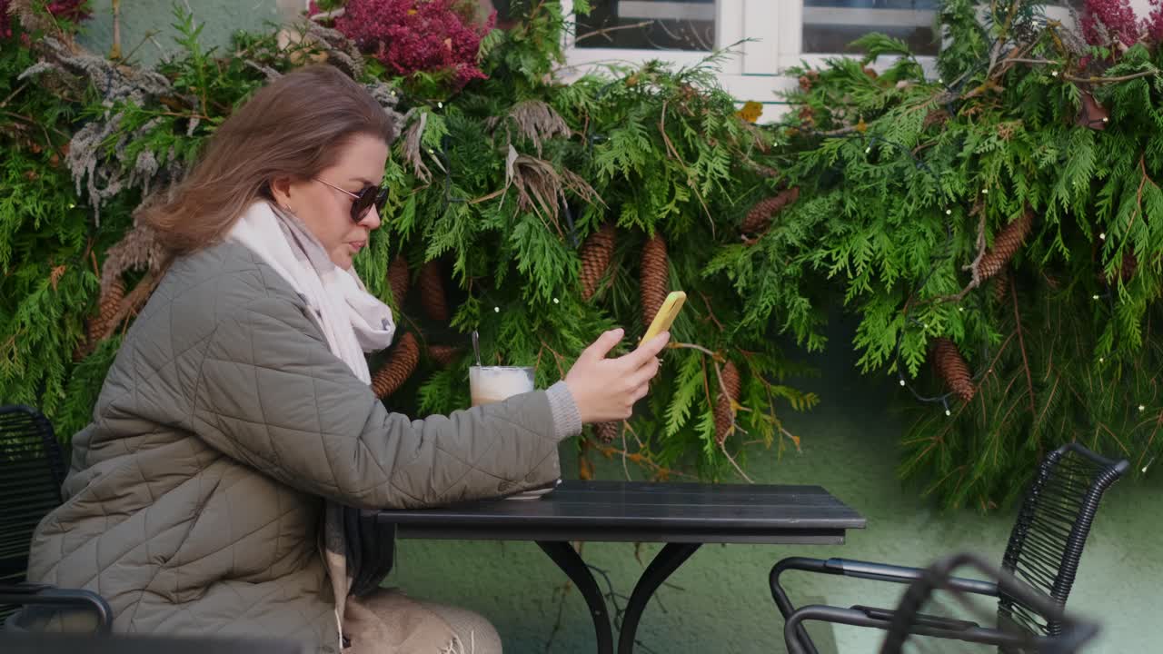 Woman using phone in a cafe during the holidays