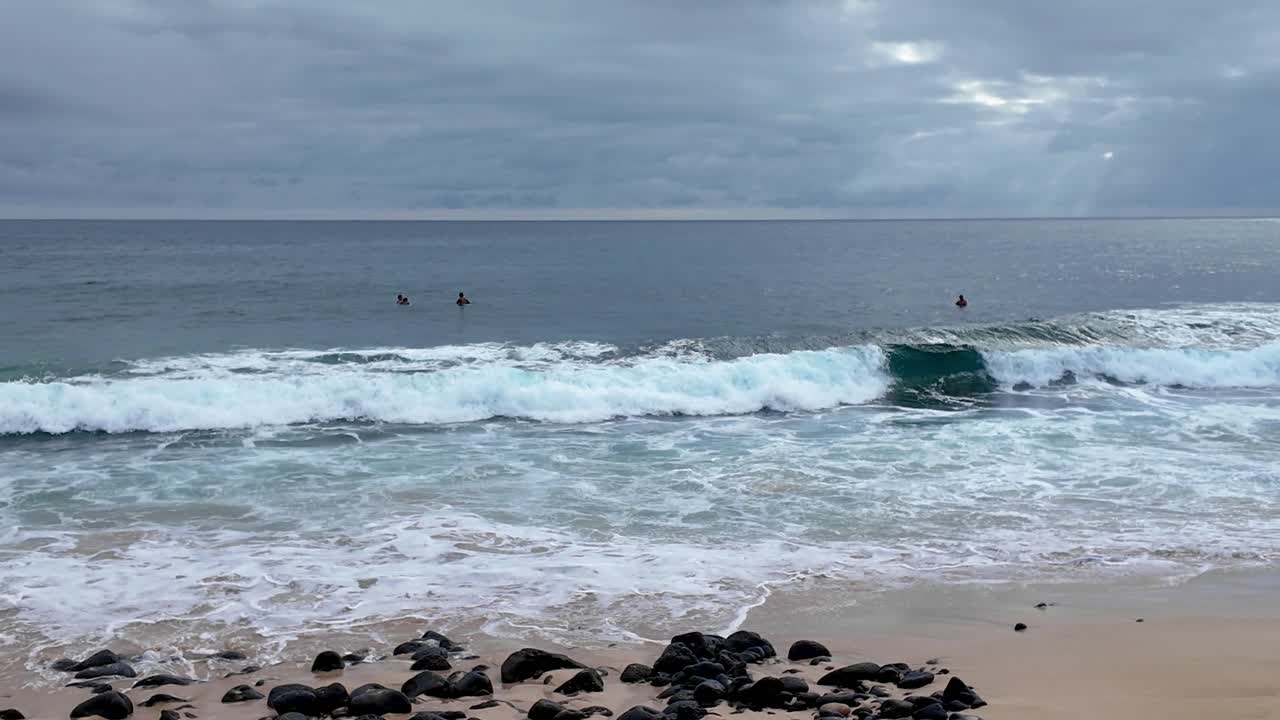 la playa del naufragio en kauai, hawai, conocida por el surf y la observación del atardecer, lugar popular para saltar de acantilados al atardecer.